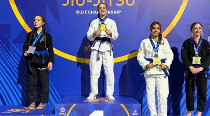 Atleta de São José, Ester Boing conquista título mundial de jiu-jitsu Atletas de jiu-jitsu posam no pódio durante o Campeonato Mundial da IBJJF, na Califórnia. Ao centro, Ester Boing aparece no lugar mais alto do pódio com a medalha de ouro, representando a conquista do título mundial da categoria faixa-azul. A imagem destaca o resultado histórico da atleta de São José no cenário internacional da modalidade.