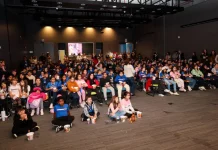 Crianças assistindo cinema pelo projeto Sapiens Parque