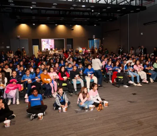 Crianças assistindo cinema pelo projeto Sapiens Parque
