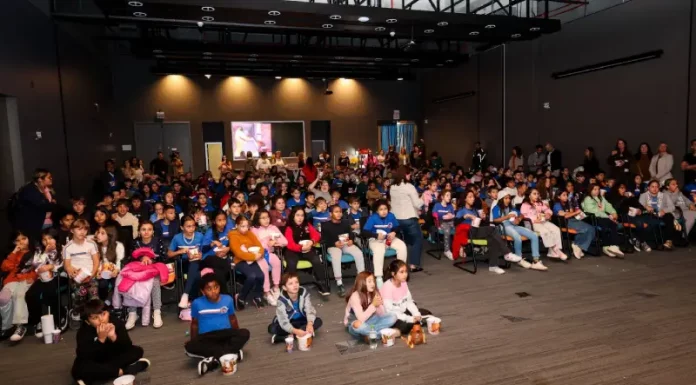 Crianças assistindo cinema pelo projeto Sapiens Parque