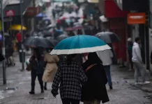 Chuva retorna a Santa Catarina no fim de semana e temperaturas seguem baixas Pessoas caminhando com guarda-chuvas no centro da cidade, mostrando que a chuva voltou no final de semana