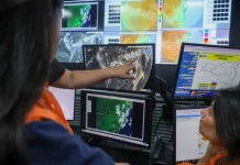 Profissionais da Defesa Civil monitoram mapas meteorológicos e imagens de satélite em centrais de computador durante ações do Decreto de alerta climático em Santa Catarina. A imagem representa o acompanhamento preventivo de eventos extremos e os preparativos do Estado diante dos riscos associados ao fenômeno El Niño.