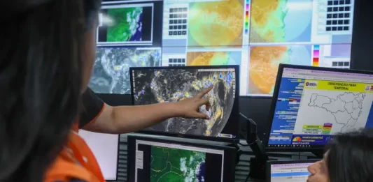 Santa Catarina adota decreto de alerta climático para eventos extremos Profissionais da Defesa Civil monitoram mapas meteorológicos e imagens de satélite em centrais de computador durante ações do Decreto de alerta climático em Santa Catarina. A imagem representa o acompanhamento preventivo de eventos extremos e os preparativos do Estado diante dos riscos associados ao fenômeno El Niño.