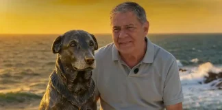 Foto do Deputado Mario Motta eo lado da estátua do cão Orelha