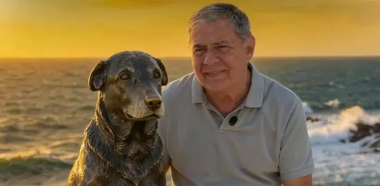 Foto do Deputado Mario Motta eo lado da estátua do cão Orelha