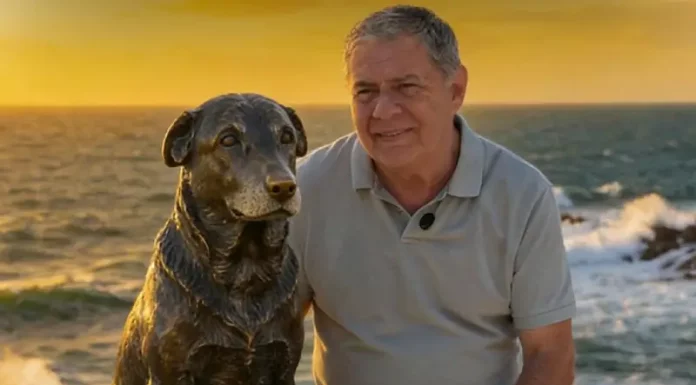 Foto do Deputado Mario Motta eo lado da estátua do cão Orelha
