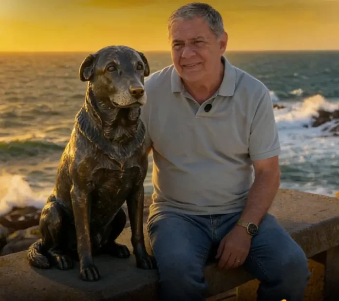 Foto do Deputado Mario Motta eo lado da estátua do cão Orelha