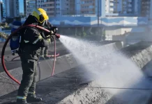 Bombeiro controlândo o fogo durante incêndio na rodoviária de Florianópolis