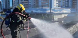 Bombeiro controlândo o fogo durante incêndio na rodoviária de Florianópolis