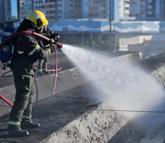 Bombeiro controlândo o fogo durante incêndio na rodoviária de Florianópolis