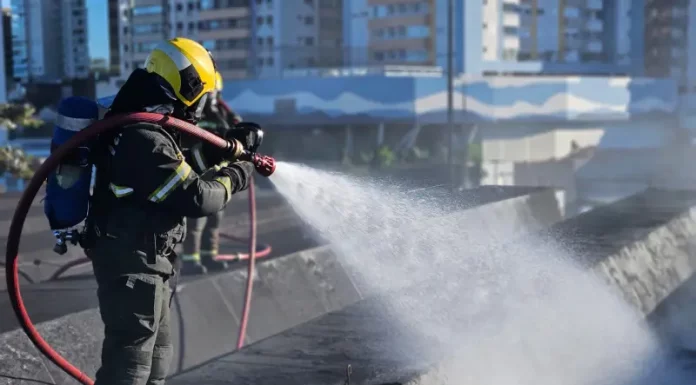 Bombeiro controlândo o fogo durante incêndio na rodoviária de Florianópolis