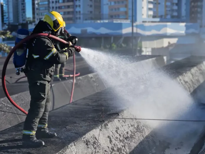 Bombeiro controlândo o fogo durante incêndio na rodoviária de Florianópolis