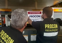 Agentes do Procon de Florianópolis colcando placa de interditado em posto de combustívies