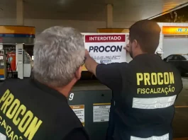 Agentes do Procon de Florianópolis colcando placa de interditado em posto de combustívies