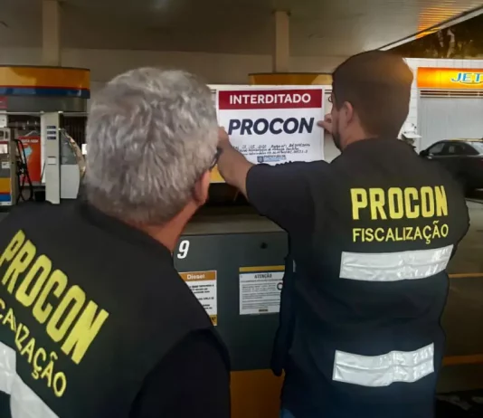Procon interdita posto em Florianópolis por falta de alvará Agentes do Procon de Florianópolis colcando placa de interditado em posto de combustívies