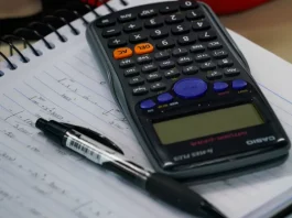 Últimos dias para aderir ao Recupera Mais com descontos no ICMS e ITCMD Mesa com calculadora, caderno e caneta, representando planejamento financeiro e organização de dívidas no contexto do programa Recupera Mais.