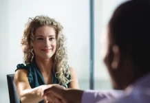 Feirão de Empregos oferece mais de 400 vagas em Biguaçu Mulher participa de uma entrevista de emprego e aperta a mão de um recrutador, representando oportunidades de contratação durante o Feirão de Empregos de Biguaçu