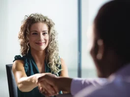 Feirão de Empregos oferece mais de 400 vagas em Biguaçu Mulher participa de uma entrevista de emprego e aperta a mão de um recrutador, representando oportunidades de contratação durante o Feirão de Empregos de Biguaçu