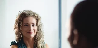 Mulher participa de uma entrevista de emprego e aperta a mão de um recrutador, representando oportunidades de contratação durante o Feirão de Empregos de Biguaçu