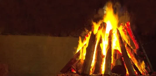 Ocorrências com fogueiras crescem 61% em SC e CBMSC alerta para festas juninas Fogueira acesa com toras de madeira empilhadas em formato triangular durante a noite. A imagem ilustra o tema das ocorrências com fogueiras e os cuidados necessários para prevenir queimaduras e incêndios durante as festas juninas.