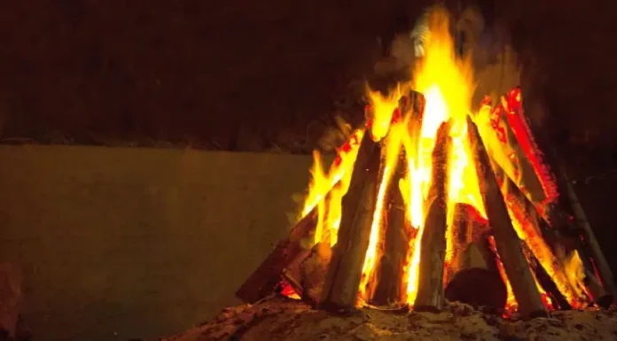 Ocorrências com fogueiras crescem 61% em SC e CBMSC alerta para festas juninas Fogueira acesa com toras de madeira empilhadas em formato triangular durante a noite. A imagem ilustra o tema das ocorrências com fogueiras e os cuidados necessários para prevenir queimaduras e incêndios durante as festas juninas.