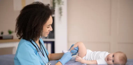 Enfermeira aplicando vacina pneumo 20 em bebe