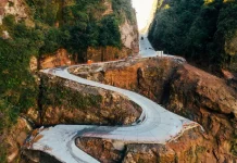Em fase final de obras, Serra do Corvo Branco terá reabertura gradual do trânsito em julho Vista aérea da Serra do Corvo Branco, em Santa Catarina, mostrando o trecho da SC-370 em obras de pavimentação em concreto. A imagem destaca as curvas da rodovia entre paredões rochosos, evidenciando os investimentos em infraestrutura, segurança viária e melhoria da ligação entre a Serra e o Litoral catarinense.