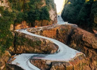 Em fase final de obras, Serra do Corvo Branco terá reabertura gradual do trânsito em julho Vista aérea da Serra do Corvo Branco, em Santa Catarina, mostrando o trecho da SC-370 em obras de pavimentação em concreto. A imagem destaca as curvas da rodovia entre paredões rochosos, evidenciando os investimentos em infraestrutura, segurança viária e melhoria da ligação entre a Serra e o Litoral catarinense.