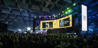 Auditório lotado durante uma edição do Summit Cidades, com público sentado diante de um grande palco iluminado e telões exibindo apresentações. A imagem ilustra a dimensão do evento, que reúne milhares de participantes para debater gestão pública, desenvolvimento urbano, inovação, mobilidade e políticas para o futuro das cidades em Florianópolis.