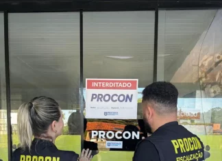 Agentes do procon de Florianópolis colocando placa de interdição em Pet Shop