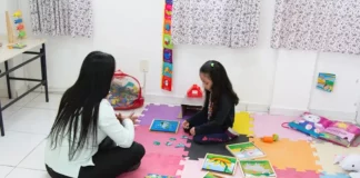 Professora de educação especial com aluna em sala de aula, simbolizando a chamada pública para professores de educação especial