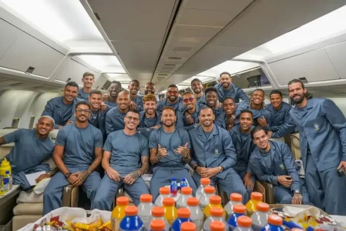 selecao-aviao-223853 (1) Jogadores e integrantes da comissão técnica da Seleção Brasileira posam para uma foto dentro da aeronave que transporta a delegação aos Estados Unidos para a disputa da Copa do Mundo de 2026. A imagem registra o embarque da equipe e o início da viagem para o torneio.