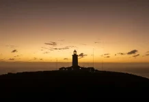 Junho começa com clima típico de outono em Santa Catarina Foto de um farol no por de sol, mostrando temperatura tipica de outono no início de junho
