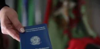 Mão segurando carteira de trabalho, simbolizando as vagas de emprego em Santa Catarina