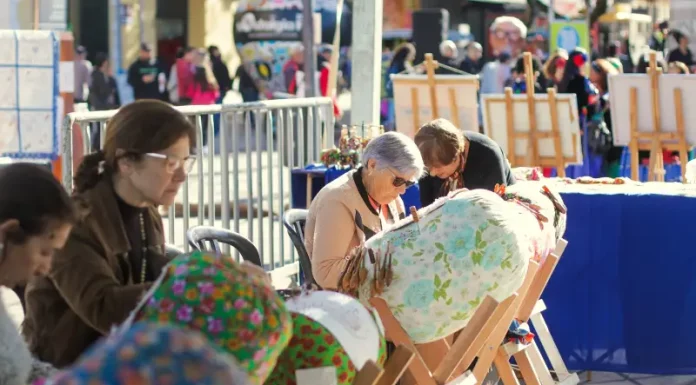 Participantes confeccionam renda de bilro durante atividade cultural ao ar livre no Largo da Alfândega, em celebração aos 39 anos da Fundação Franklin Cascaes, em Florianópolis.