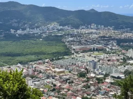 Plano Diretor define regras para Áreas de Urbanização Específica em Florianópolis Vista panorâmica de Florianópolis mostra áreas urbanizadas, vegetação preservada e bairros da Capital, ilustrando o crescimento urbano e o planejamento territorial previsto no Plano Diretor.