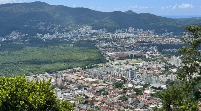 Plano Diretor define regras para Áreas de Urbanização Específica em Florianópolis Vista panorâmica de Florianópolis mostra áreas urbanizadas, vegetação preservada e bairros da Capital, ilustrando o crescimento urbano e o planejamento territorial previsto no Plano Diretor.