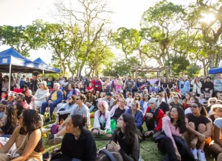 Foto mostra pessoas sentadas em área do Jardim Botânico prestigiando o Festival Tanabata Matsuri