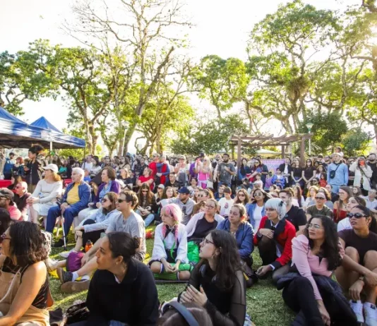Tanabata Matsuri leva cultura japonesa ao Jardim Botânico de Florianópolis Foto mostra pessoas sentadas em área do Jardim Botânico prestigiando o Festival Tanabata Matsuri