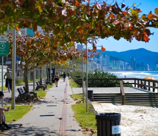 Frio perde força e calor volta a ganhar intensidade em Santa Catarina Pessoas caminham e pedalam no calçadão à beira-mar em dia de sol em Santa Catarina, ilustrando o contraste entre as manhãs de frio intenso e a elevação das temperaturas prevista para os próximos dias.