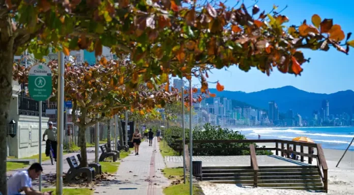 Frio perde força e calor volta a ganhar intensidade em Santa Catarina Pessoas caminham e pedalam no calçadão à beira-mar em dia de sol em Santa Catarina, ilustrando o contraste entre as manhãs de frio intenso e a elevação das temperaturas prevista para os próximos dias.