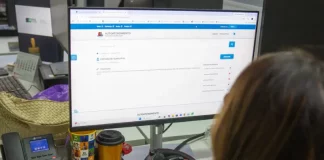 Servidora da prefeitura de São José olhando a tela de computador para solicitação de isenção do IPTU