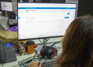 Servidora da prefeitura de São José olhando a tela de computador para solicitação de isenção do IPTU