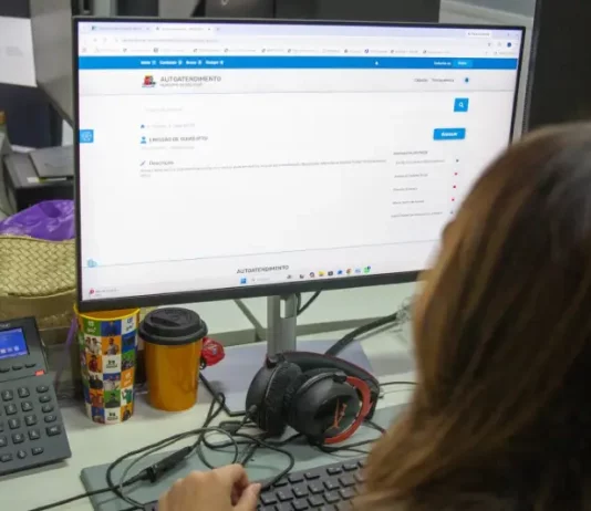 Servidora da prefeitura de São José olhando a tela de computador para solicitação de isenção do IPTU