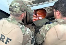 Agentes da PRF retirando as drogas de compartilhamento em caminhão qu resultou na prisão de um motorista paraguaio