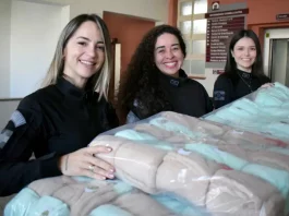 Agentes da Polícia Penal entregando mantas na maternidade Carmela Dutra