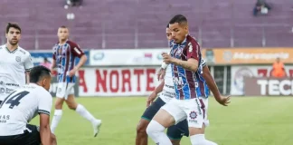 Jogadores de Caxias e Figueirense disputam partida de futebol no Estádio Centenário.
