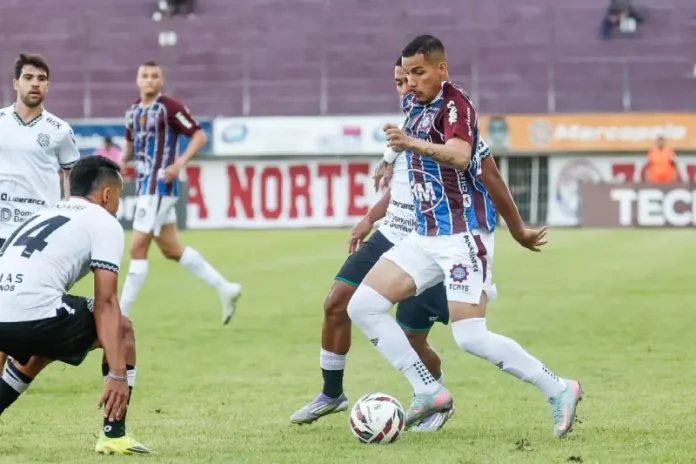 Jogadores de Caxias e Figueirense disputam partida de futebol no Estádio Centenário.
