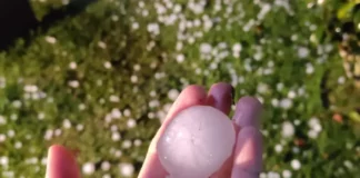 Pessoa segurando granizo na mão após temporal em Florianópolis