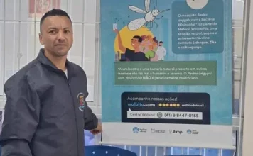 Homem participa de ação de divulgação do Método Wolbachia, com material informativo sobre a tecnologia usada no combate à dengue, Zika e chikungunya.